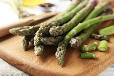 Taze çiğ kuşkonmaz mızrakları ve bıçak masanın üstünde, yakın plan.