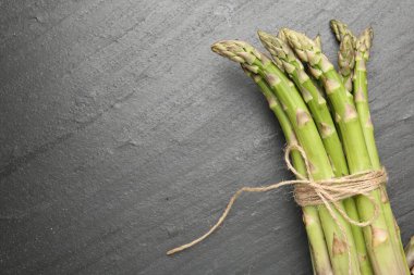 Siyah masada taze çiğ kuşkonmaz mızrakları, üst manzara. Metin için boşluk