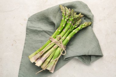 Açık gri masada taze çiğ kuşkonmaz.
