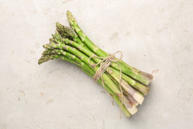 Açık gri masada taze çiğ kuşkonmaz.