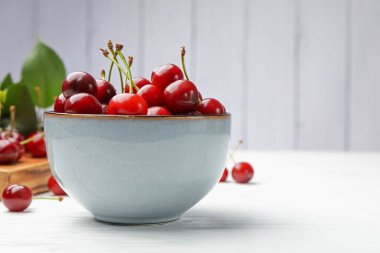 Beyaz ahşap masada taze kirazlar, yakın plan. Metin için boşluk