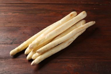 Pek çok çiğ kuşkonmaz, ahşap masada, manzaranın üstünde.