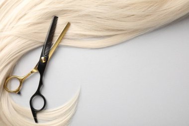 Sarı saç tokası ve makas açık gri arka plan, üst manzara. Metin için boşluk