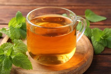 Cam bardakta Aromatik limon merhemi çayı ve masada taze yapraklar, yakın plan.