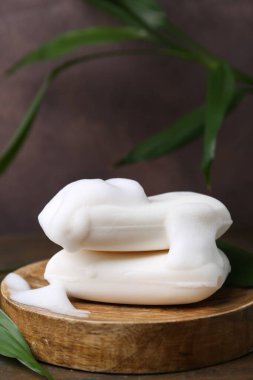 Köpüklü sabun çubukları ahşap masada, yakın plan.