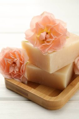 Sabun çubukları ve beyaz ahşap masada güzel çiçekler, yakın plan.