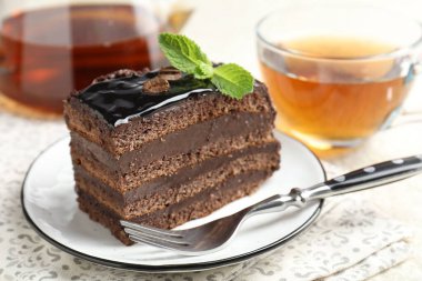 Nane, çatal ve çayla servis edilen çikolatalı kek.