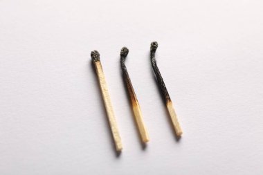 Açık gri arkaplanda yanmış kibritler, yakın plan