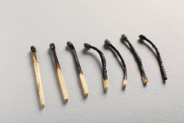 Gri arkaplanda yanmış kibritler, yakın plan görünümü