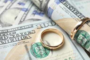 Altın alyanslar ve dolar banknotları, yakın plan.