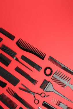 Kırmızı arka planda farklı kuaför aletleri var. Metin için boşluk