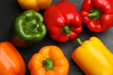 Taze renkli dolmalık biberler koyu gri masada, düz yatıyordu