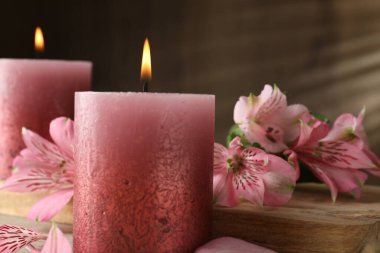 Yanan mumlar ve zambak çiçekleri masada, yakın plan.