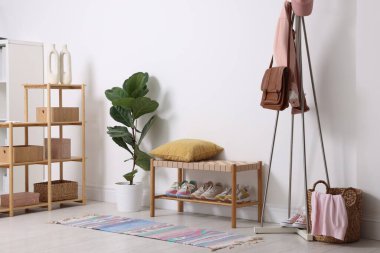 Koridorda farklı ayakkabı, giysi ve aksesuarlar var.