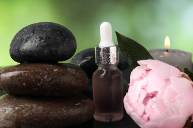 Islak taşlar, damlatıcı ve çiçekli spa kompozisyonu koyu yeşil arka planda, yakın plan