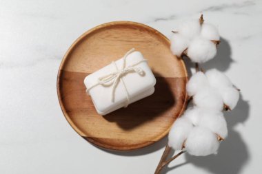 Sabun çubukları ve pamuk çiçekleri beyaz mermer masada, düz yatıyordu.