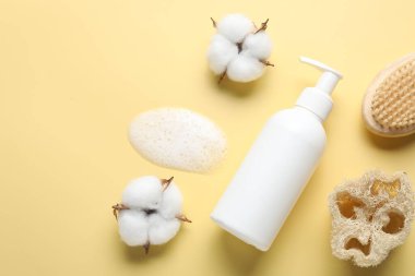 Düz kompozisyon, sarı zemin üzerinde sıvı sabun ve pamuk çiçekleri vardı. Metin için boşluk