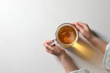 Beyaz masada cam bardakta birası olan bir kadın. Metin için boşluk