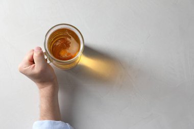 Beyaz masada cam bardak bira taşıyan bir adam, üst manzara. Metin için boşluk