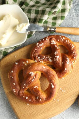 Tuz ve tereyağlı lezzetli krakerler açık gri masada, düz yerde.