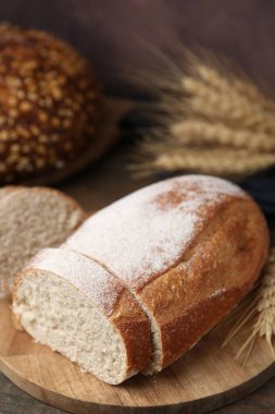 Taze kesilmiş ekmek ve çiviler ahşap masada, yakın plan.