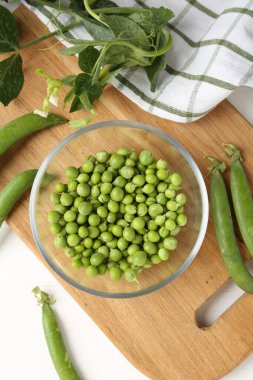 Taze taze bezelyeler beyaz ahşap masada, düz yatıyordu.