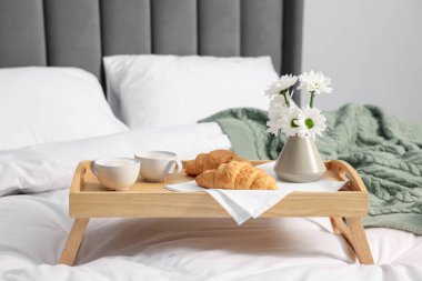 Nefis bir kahvaltı tepsisi ve kapalı bir odada çiçekler, yakın plan. Metin için boşluk