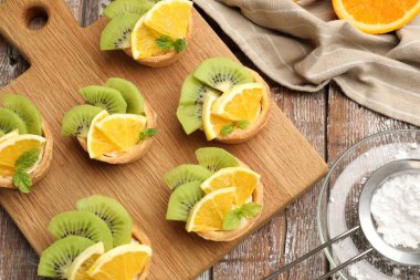 Meyveli tart, nane ve pudra şekeri ahşap masada, düz bir şekilde. Tatlı nefis.