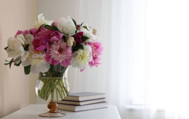 Bir buket güzel şakayık ve beyaz masa üzerinde kitaplar, yazı için yer. İç tasarım