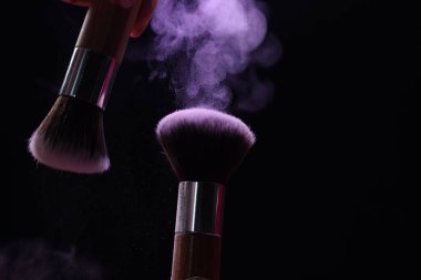 Siyah arka planda mor göz farlı makyaj fırçaları, yakın plan