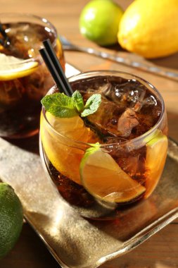 Küba libre kokteylini ahşap masada nane şekeri ile tazeliyorum.