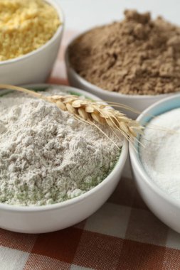 Tabaklardaki farklı un türleri ve masaya çiviler, yakın plan.