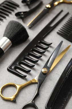 Gri masadaki farklı kuaför aletleri, yakın plan.