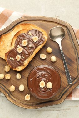 Lezzetli çikolatalı tostlar ve fındıklar ışık masasında.