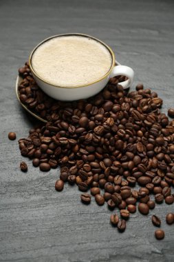 Kahve fincanda, fasulye siyah masada, yakın plan.