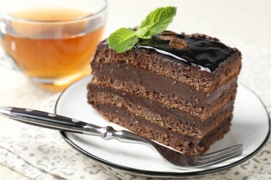 Nane, çatal ve çayla servis edilen çikolatalı kek.