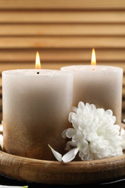 Yakıcı mumlar ve siyah masada güzel çiçekler, yakın plan.