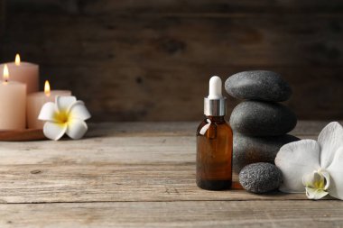 Kozmetik ürünleri ve spa taşlarıyla ahşap masaya yakın plan kompozisyonu. Metin için boşluk