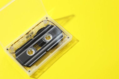 Sarı arka planda, açık kutuda bir ses kaseti. Metin için boşluk
