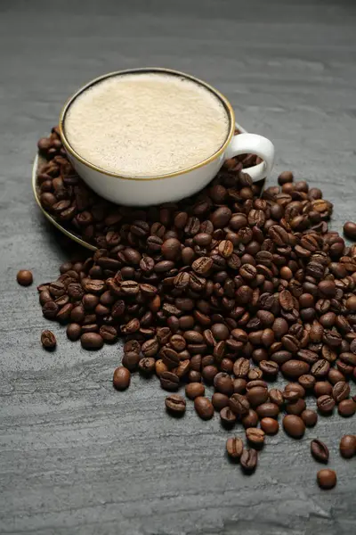 Kahve fincanda, fasulye siyah masada, yakın plan.