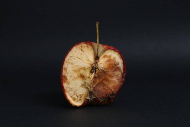 Bozuk elmanın yarısı siyah arka planda