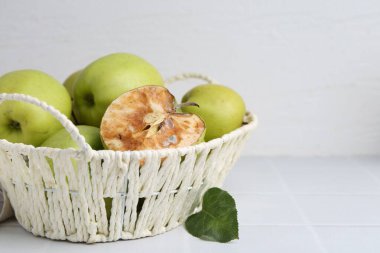 Şımarık elma ve iyi elmalar beyaz masada, yakın plan.