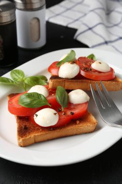 Peynirli, domatesli, fesleğenli ve çatallı lezzetli sandviçler.