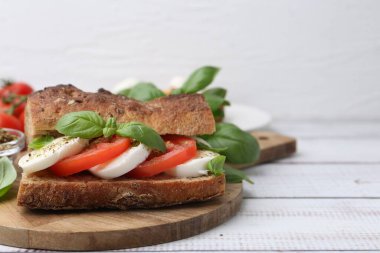 Mozarella peynirli, domatesli, fesleğenli, beyaz ahşap masa, yakın plan. Metin için boşluk