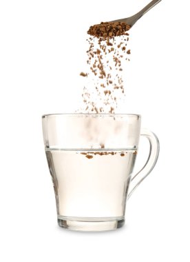 Kaşıktan cam fincana granüle edilmiş kahve ekliyorum. Kaynatılmış su beyaz, yakın plan.