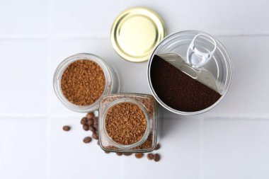 Kavanozlarda kahve ve beyaz fayanslı masada fasulye.