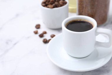 Aromatik sıcak içecek, hazır kahve ve fasulye beyaz mermer masada, yakın plan. Metin için boşluk