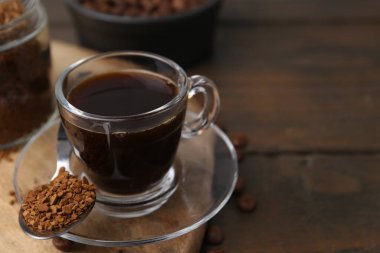 Aromatik sıcak içecek, hazır kahve ve fasulye ahşap masada, yakın plan. Metin için boşluk