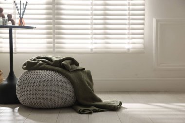 Ev dekoru ve ekose desenli şık örülmüş bir puf. Metin için boşluk