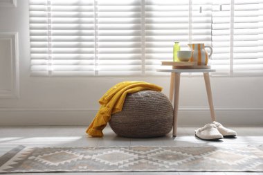 Evde şık örülmüş bir puf ve süveter. Metin için boşluk